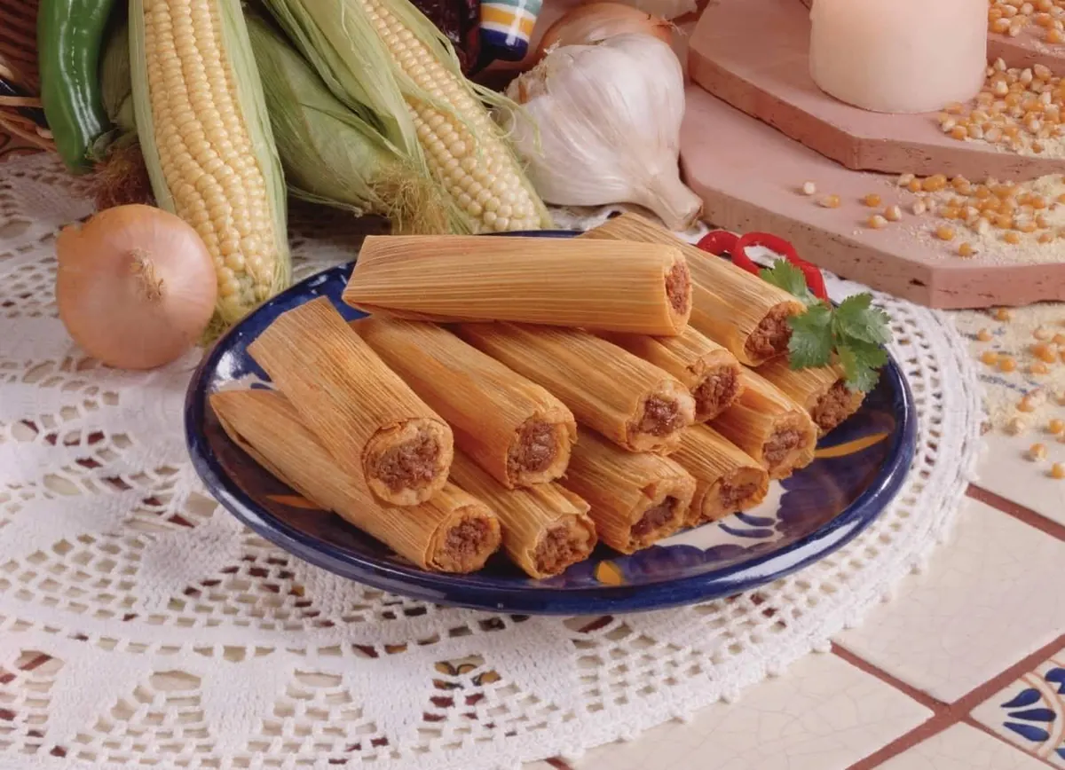 Tamales in corn husks on a plate